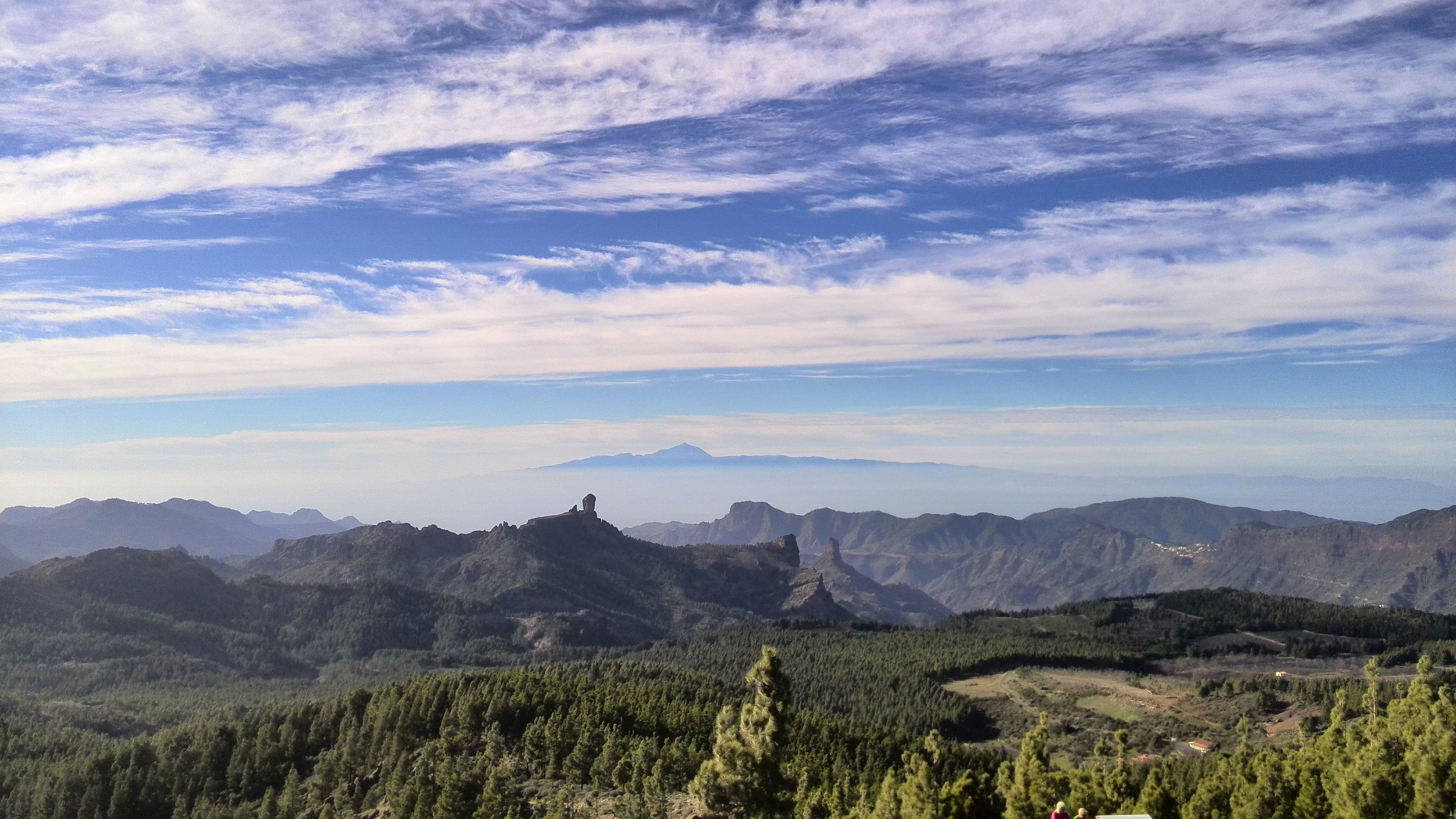 Gran Canaria's Roque Nublo and pine forests, with Tenerife's Mount Teide on the horizon